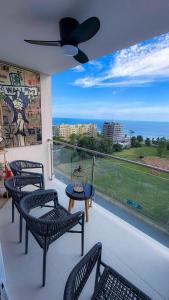 a balcony with chairs and a table and a view of the ocean at Luxury Condo at Live Jaco Tower in Jacó
