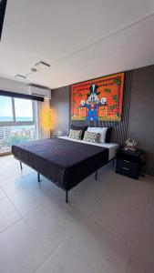 a bedroom with a large bed with a painting on the wall at Luxury Condo at Live Jaco Tower in Jacó +69 photos