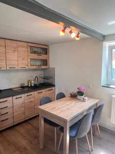 a kitchen with a wooden table and chairs at Apartament de'Lux in Żywiec