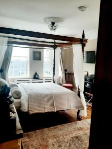 a bedroom with a canopy bed and a window at Riverside Lodge in Carlingford