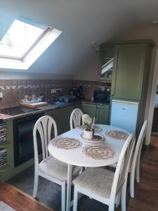 a kitchen with a white table and chairs in a kitchen at Riverside Lodge in Carlingford