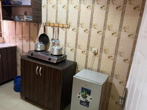 a kitchen with a stove and a small refrigerator at Electra Serviced 1 Bedroom Apartment, Lagos in Iju Junction