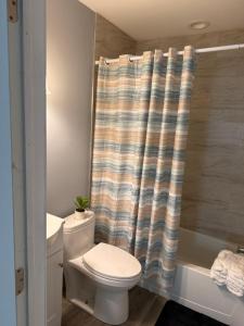a bathroom with a toilet and a shower curtain at Ben house in Baltimore