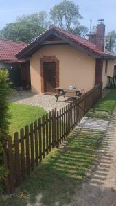 a house with a wooden fence in front of it at Domek w Zaciszu in Cieszyno