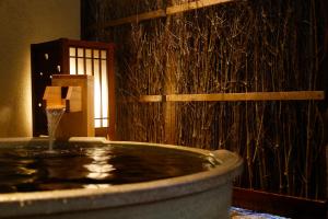 Dormy Inn Toyama Natural Hot Spring في توياما: حوض استحمام مع نافورة مياه في الغرفة