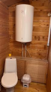 a bathroom with a toilet and a water tank at Anna Beach Holiday Home in Raja
