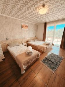 a bedroom with two beds and a large window at Pensiunea Johanna in Arad