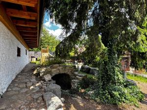 a stone bridge with a tree next to a building at Apartmány Moravský Kras Vavřinec in Vavřinec