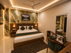 a hotel room with a bed and a table and a desk at Hotel Bellamontan Suites Near Delhi Airport - Free Airport Pickup & Drop in New Delhi