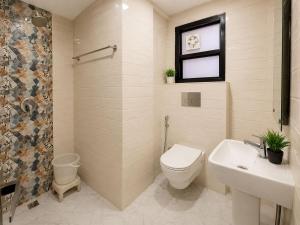 a bathroom with a toilet and a sink at Hotel Bellamontan Suites Near Delhi Airport - Free Airport Pickup & Drop in New Delhi
