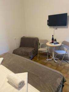 a living room with a bed and a table and a tv at Ganzha Appart in Medulin