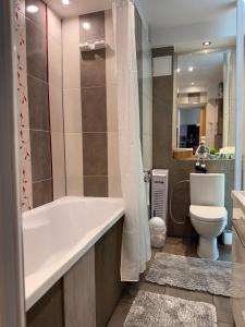 a bathroom with a tub and a toilet at Apartament Szafir in Gdańsk +8 photos