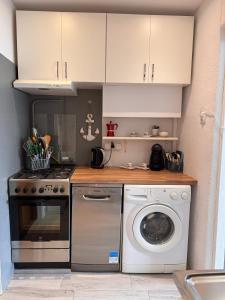 a kitchen with a washing machine and a washer at Apartament Szafir in Gdańsk