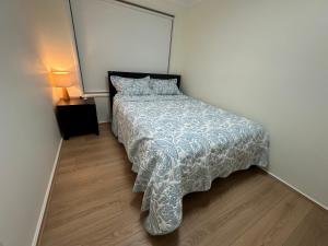 a bedroom with a bed with a comforter on it at Private Rm3 with Queen bed in Elderslie