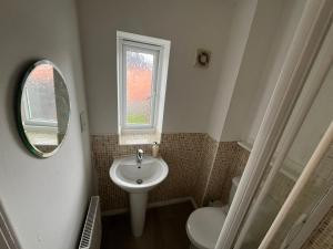 a small bathroom with a sink and a window at Favour homes in Manchester
