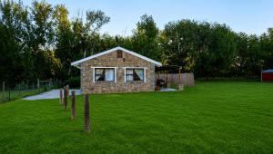 a small stone house in a field of grass at Eseltjiesrus in Nieu-Bethesda