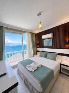 a bedroom with a bed with a view of the ocean at Carpe Diem Hotel in Finike