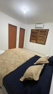 a bedroom with a large bed with pillows on it at Villa Serrinha - Sitio Paraiso in Serrinha +7 photos