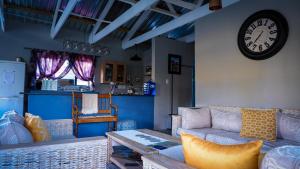 a living room with a couch and a clock on the wall at Eseltjiesrus in Nieu-Bethesda