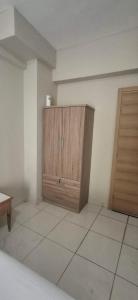 a room with a wooden cabinet and a tiled floor at Alekas Garden View Studios in Kos