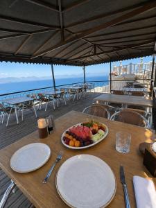 a table with plates and a bowl of fruit on it at Carpe Diem Hotel in Finike