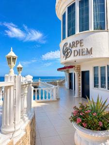 a building on the beach with the ocean in the background at Carpe Diem Hotel in Finike