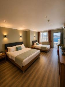 a hotel room with two beds and a window at Carpe Diem Hotel in Finike