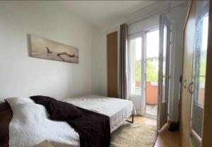 a bedroom with a bed and a large window at home santos in Tulle