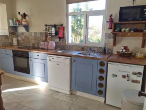 a kitchen with blue cabinets and a sink and a window at Lakeside house in Oughterard