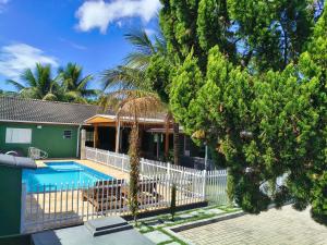 a house with a swimming pool and a fence at Recanto Vila Madalena in Caçapava