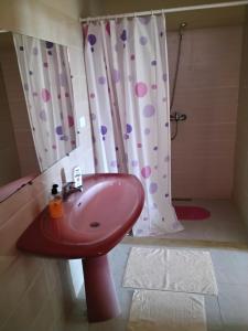 a bathroom with a pink sink and a shower at Résidence Kyranis appartement Noix de Coco in Sfax +3 photos