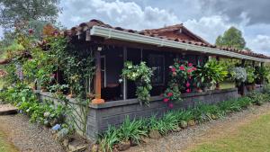 a house with a bunch of flowers and plants at Casa campestre in Guarne