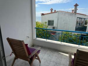 a balcony with two chairs and a view of a building at Thomi's house. in Yerakiní