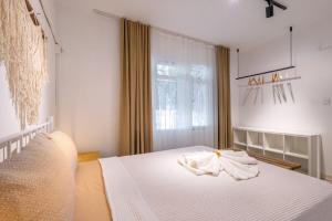 a bedroom with a bed with white sheets and a window at 7a old Marmaris house in Marmaris