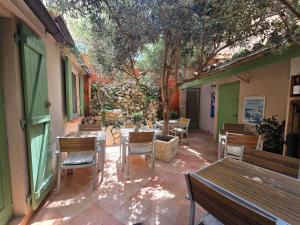 a patio with wooden tables and chairs and a building at Hôtel Le Colbert in Avignon