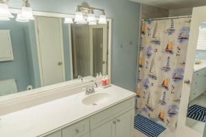 a bathroom with a sink and a shower curtain at Mariners Village Tranquil Condo in Seabrook +7 photos