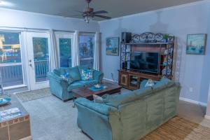 a living room with two couches and a television at Mariners Village Tranquil Condo in Seabrook