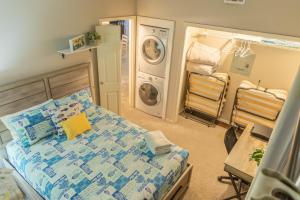 a bedroom with a bed and a washing machine at Mariners Village Tranquil Condo in Seabrook