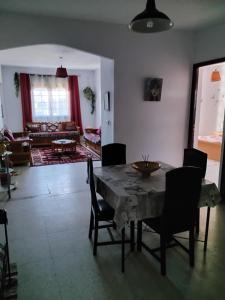 a living room with a wooden table and chairs at Résidence Kyranis appartement Noix de Coco in Sfax
