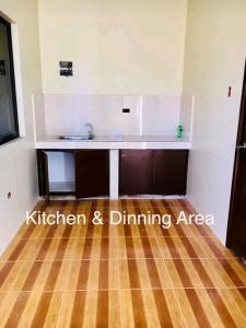 a kitchen and dining area with a sink and a wooden floor at Mendoza's Apartment in Tuy