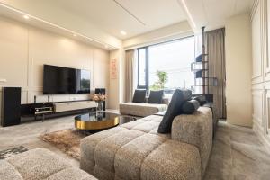 a living room with a couch and a tv at ZJ Villa in Sanxing