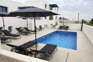 a pool with chairs and umbrellas next to a building at Sunny & Blue in Parasporos