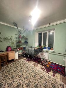 a room with a bed and a table and a window at Arlanguesthouse in Dzhangyaryk