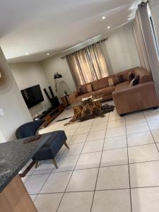 a living room with a couch and a table at Caly Luxury Home in Nelspruit