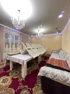a room with a table and two beds in it at Arlanguesthouse in Dzhangyaryk