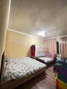 a small bedroom with a bed and a couch at Arlanguesthouse in Dzhangyaryk +2 photos