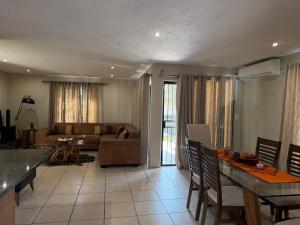 a living room with a couch and a table at Caly Luxury Home in Nelspruit