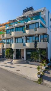 a large building with palm trees in front of it at Apartmens Aida Luks in Ulcinj