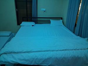 a large blue bed with blue sheets and pillows at Shree krishn yatri nivas in Ellora