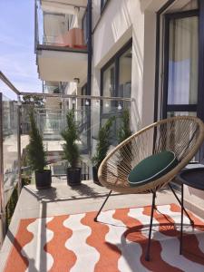 a balcony with a chair and plants on a building at Apartament VerdeMar in Rowy